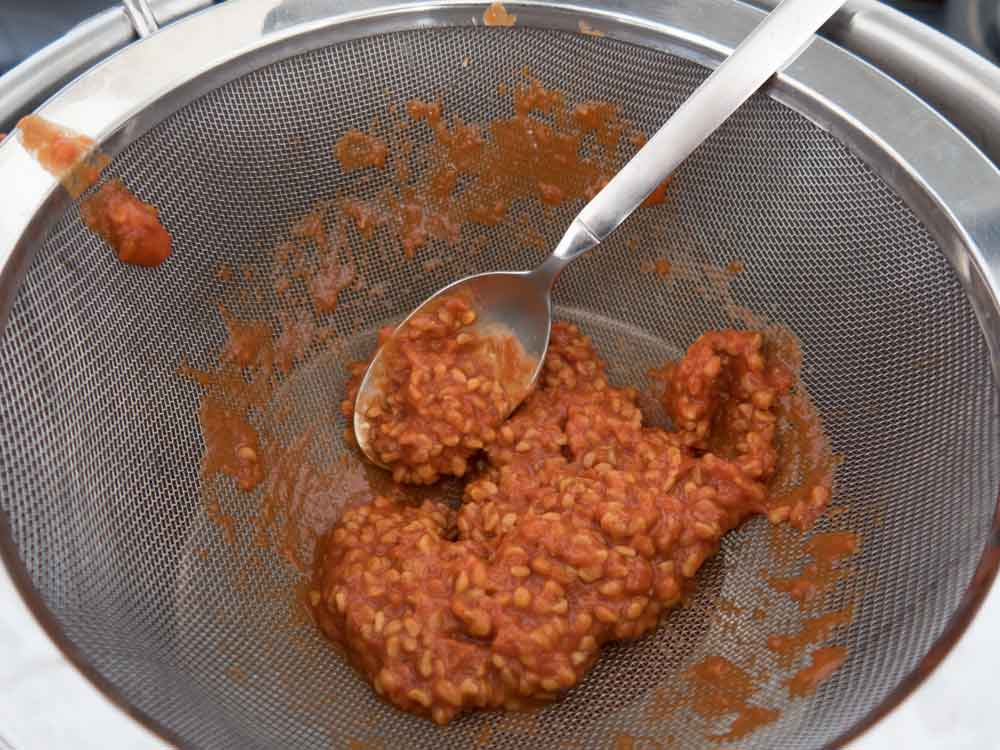 gekochtes Hagebuttenmus durch Sieb pasieren
