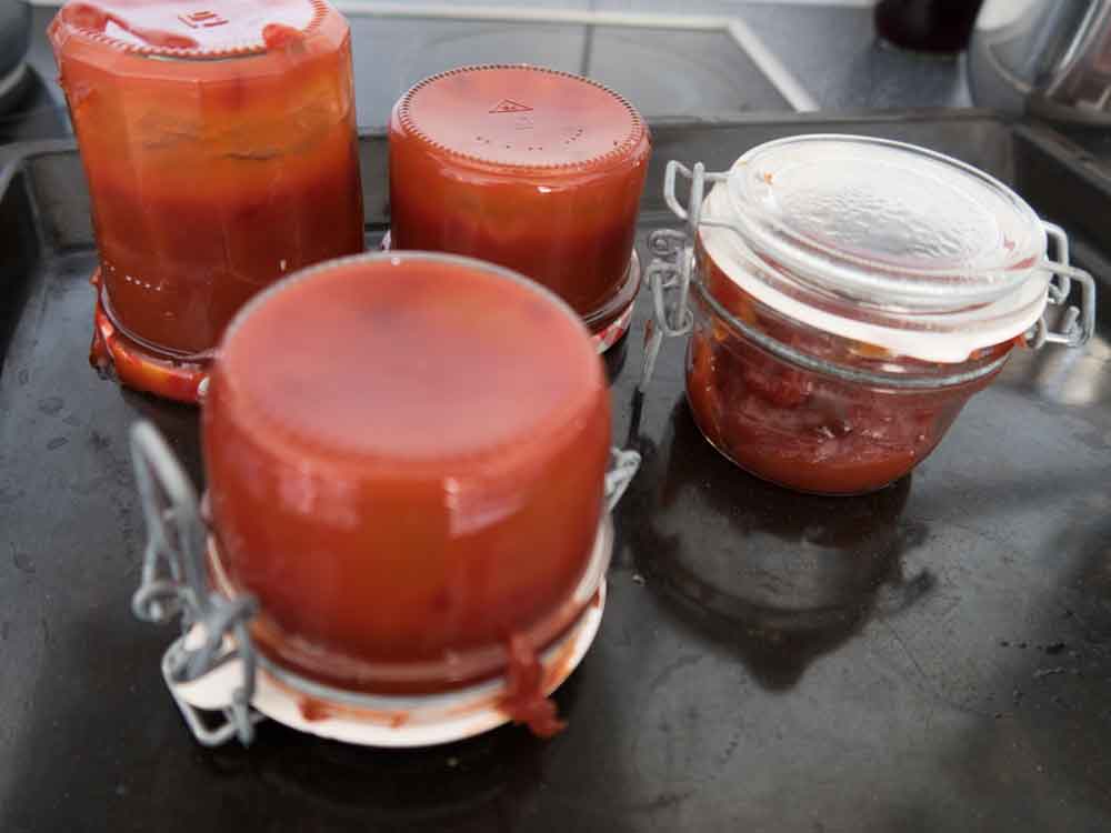 Gläser mit heißer Hagebutten Marmelade auf den Kopf stellen