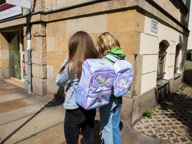 Mädchen mit Schulranzen und Rucksack