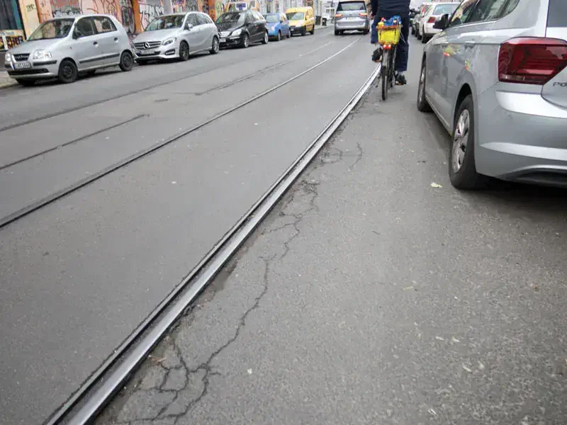 Fahrradunfall Straßenbahngleis, weil Autos falsch parken